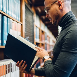 male student reading in library