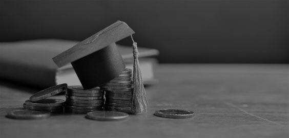 image of graduation cap sitting on top of money
