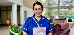Caitlin McCourt posing with her award