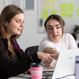 two people working on a laptop