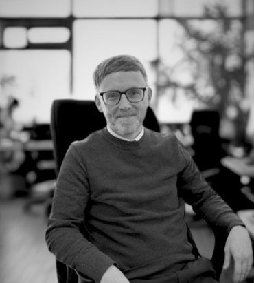 Picture of man sitting on a chair smiling at the camera