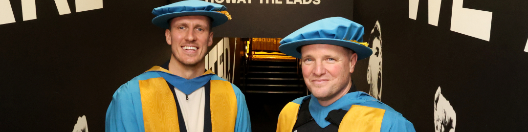 Image of Eddie Howe and Dan Burn in graduate gowns