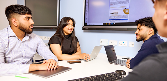 Four students engaging in a simulated Business School project.