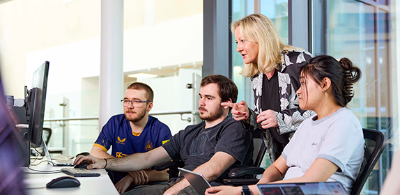 Students and an academic at a computer