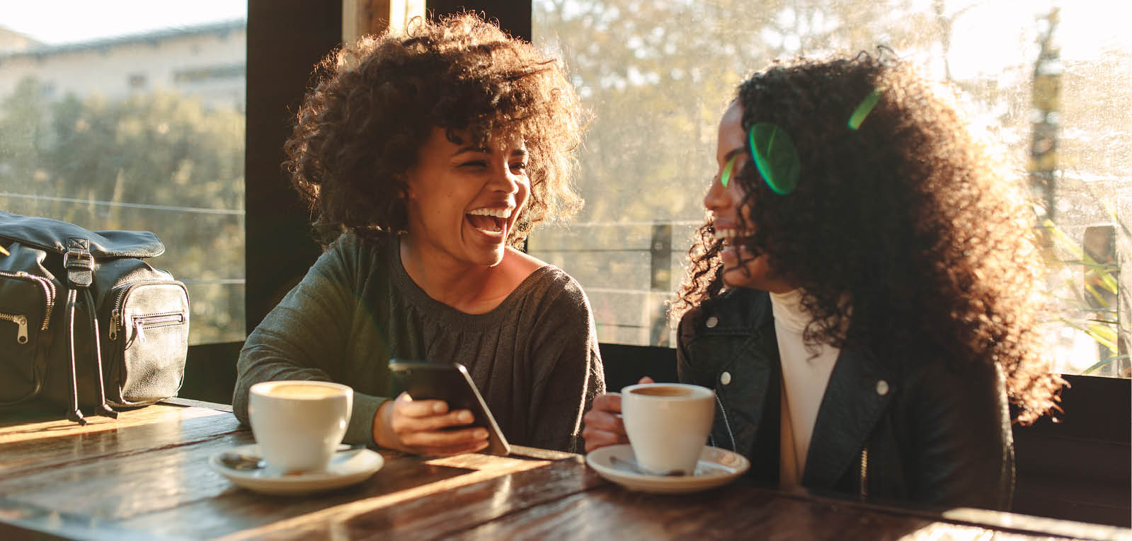 Two women laughing and having coffee