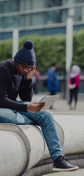 a man sitting in a chair talking on a cell phone
