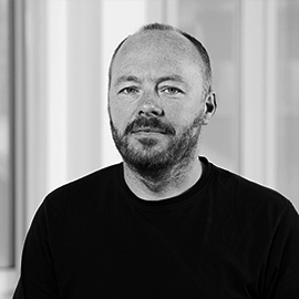 a man standing in front of a window posing for the camera