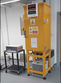 The NSTL X-Ray irradiator is a yellow box about the size of a person with radiation warning signs.