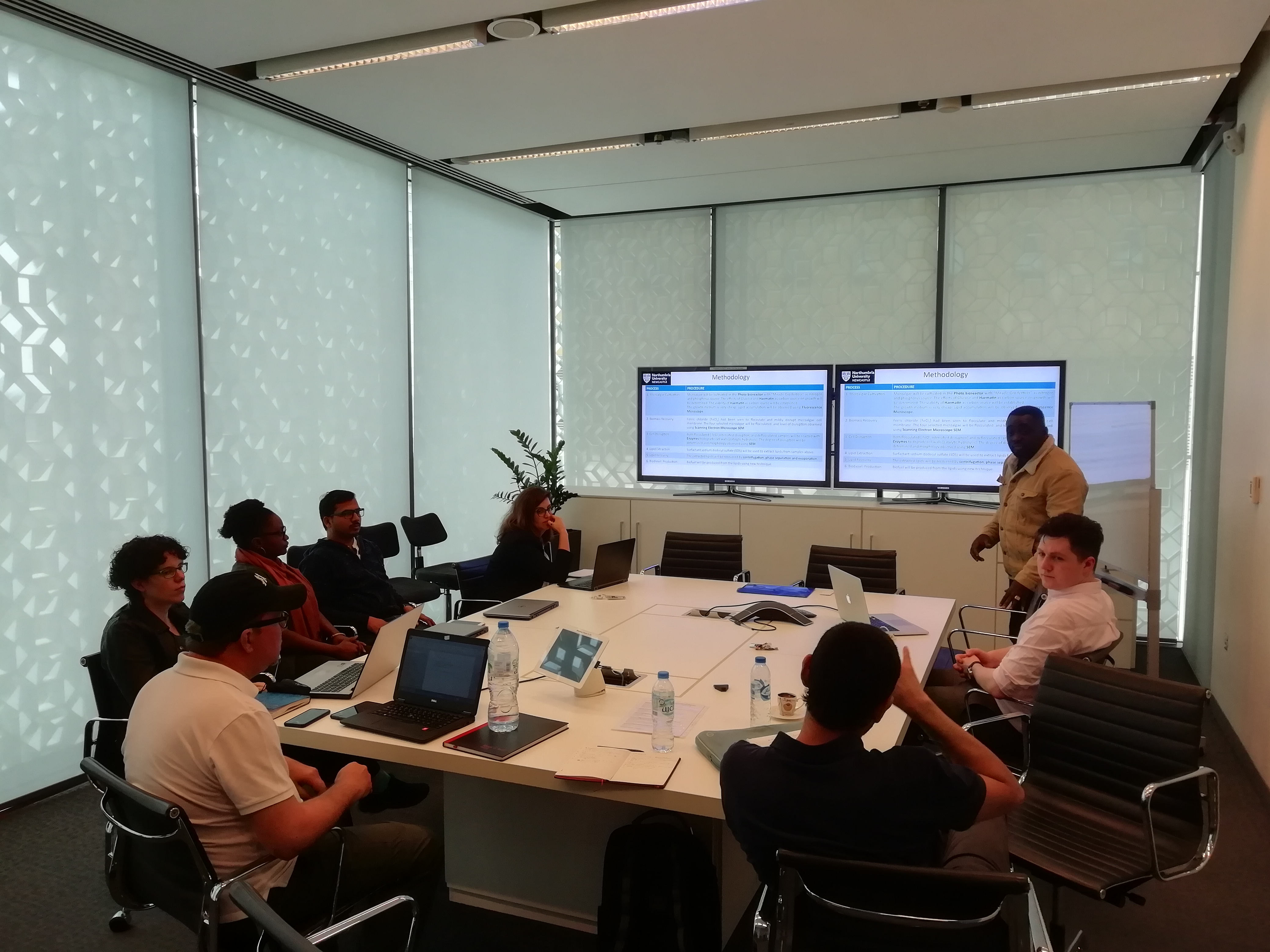 a group of people sitting at a desk in front of a computer