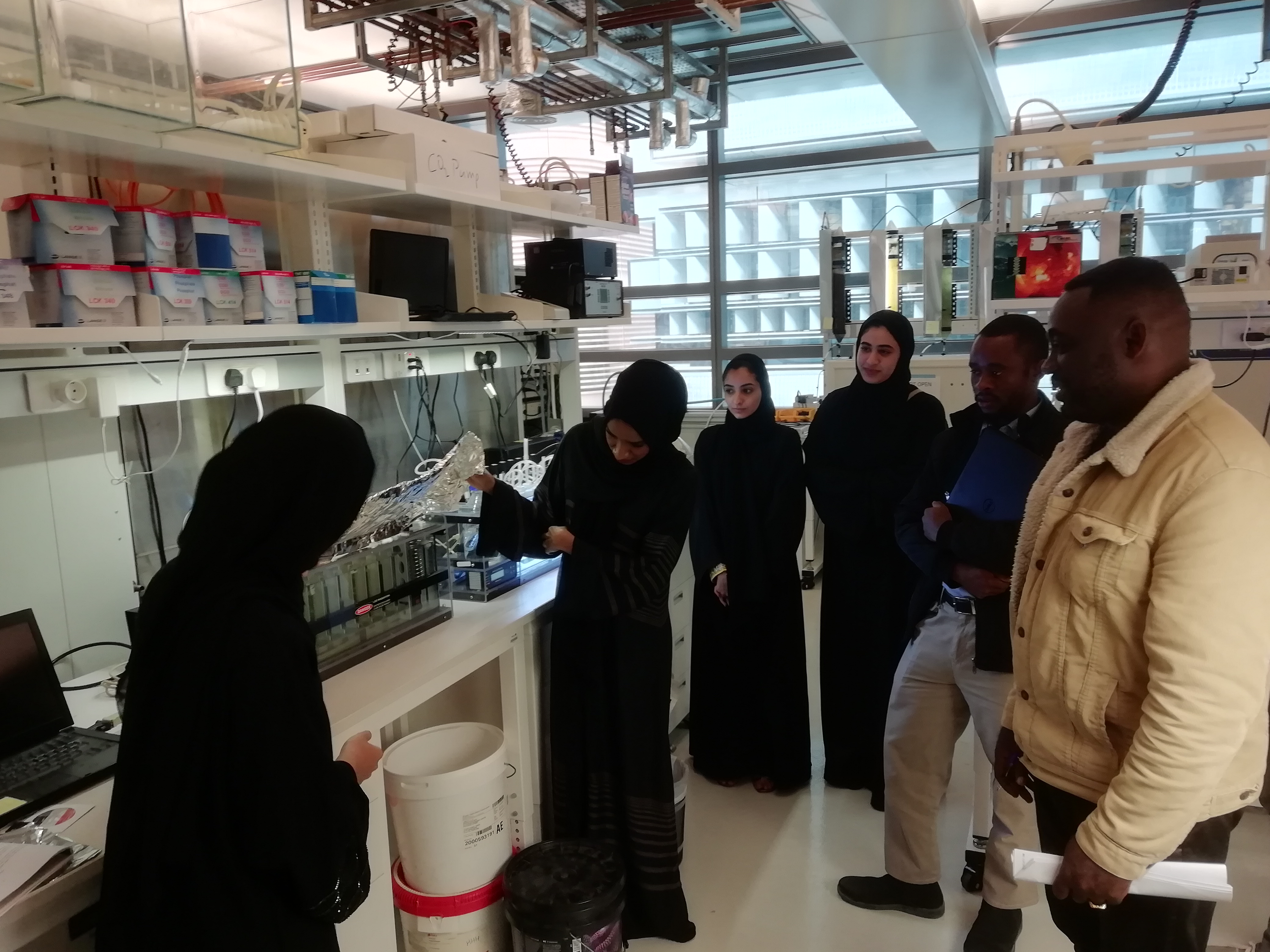 a group of people standing in a kitchen