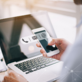 holding a phone with emails open