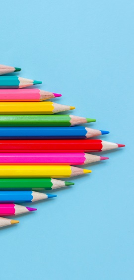 Pencils in different shades positioned into a triangular shape on a light blue background