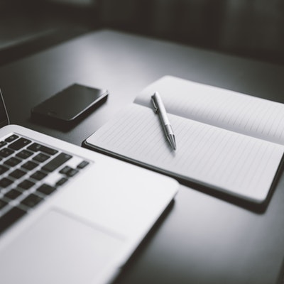 notepad open next to a laptop