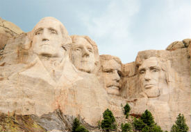 a close up of an old building with Mount Rushmore National Memorial in the background