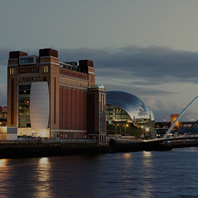 Wide-shot of Baltic 99 and The Sage at Newcastle Quayside as the sun sets in the distance.