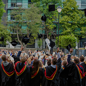 Group of graduates in their robes, throwing up their caps