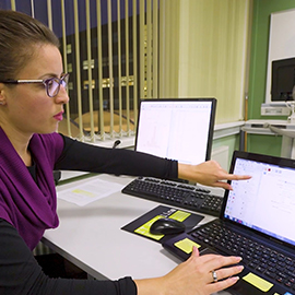 a person sitting at a table using a laptop computer
