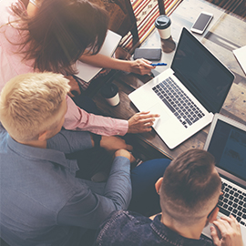 a group of people looking at a laptop