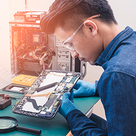 a person sitting at a table looking at a laptop