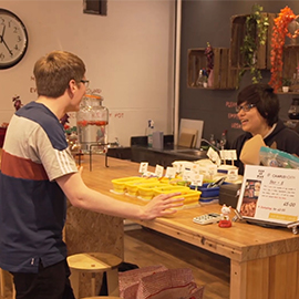 a group of people standing in a kitchen preparing food