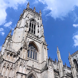 a large tall tower with a clock on the side of a building