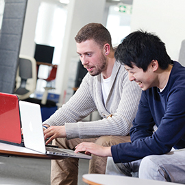 a group of people looking at a laptop