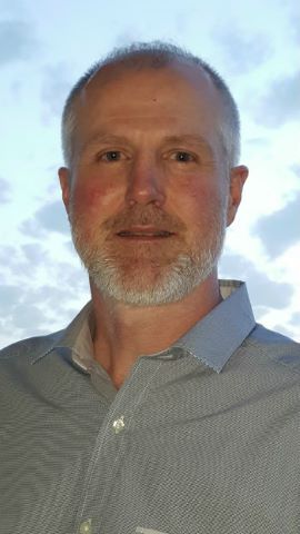 a man wearing glasses posing for the camera