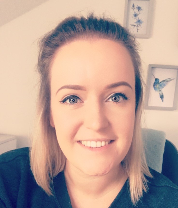 a woman wearing a blue shirt and smiling at the camera