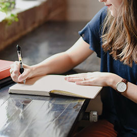 Photo of woman writing in a notebook
