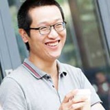 a person wearing glasses and smiling at the camera