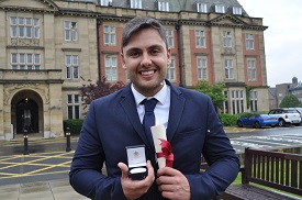 a man wearing a suit and tie standing in front of a building