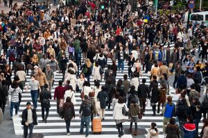 a group of people walking down the street in front of a crowd