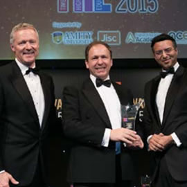 a group of people standing next to a person in a suit and tie