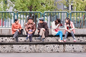 a group of people riding on top of a wooden fence