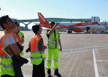 a group of people standing around a plane