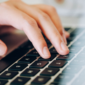Person typing on a laptop keyboard