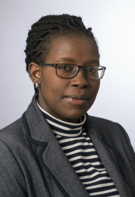 a man wearing a suit and tie smiling and looking at the camera