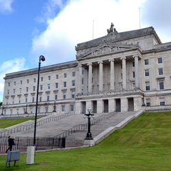 a castle on top of a grass covered field with Parliament Buildings in the background