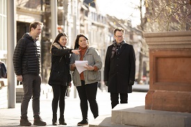 a group of people walking on a sidewalk