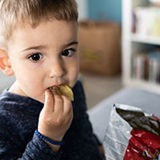 a young boy eating a banana