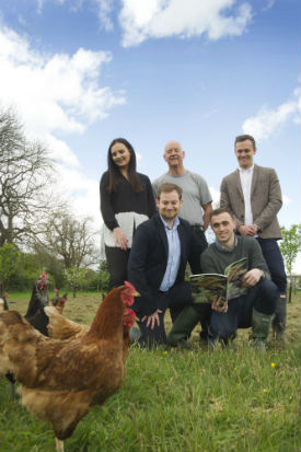 a group of people standing in a grass field posing for the camera