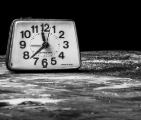 a clock sitting in front of a body of water