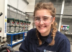 a person wearing glasses and smiling at the camera