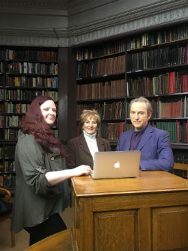 a group of people sitting at a desk in front of a book shelf