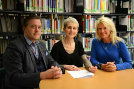 a group of people sitting at a table with a book shelf