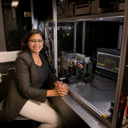 Dr Juna Sathian pictured sitting down next to a MASER device