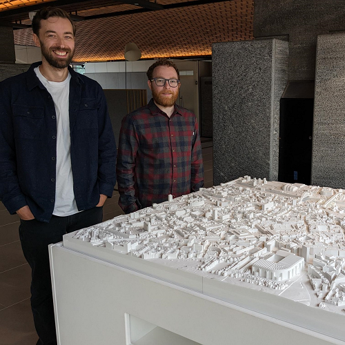 Caption: James Charlton (L) and Adam Cosheril (R) stood with the model at its new location in Newcastle Civic Centre