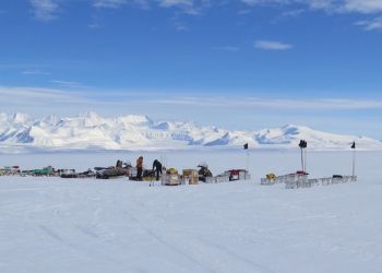 a group of people standing on top of a snow covered slope