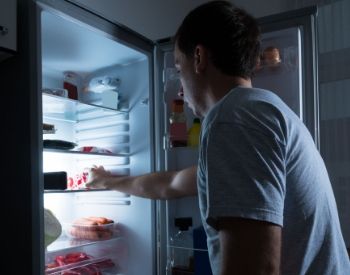 a man standing in front of a refrigerator with the door open
