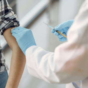 Person receiving a vaccination in arm